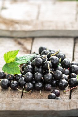 Ahşap bir masada siyah frenk üzümü.