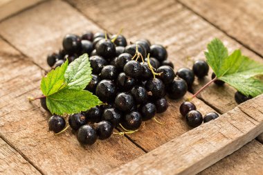 Ahşap bir masada siyah frenk üzümü