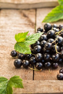 Ahşap bir masada siyah frenk üzümü.