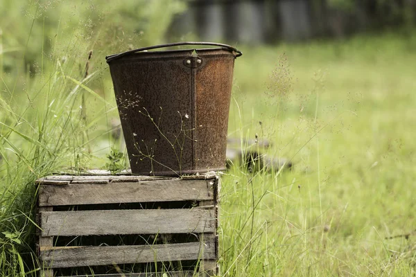 An old iron bucket at wooden pallet — Stock Photo, Image