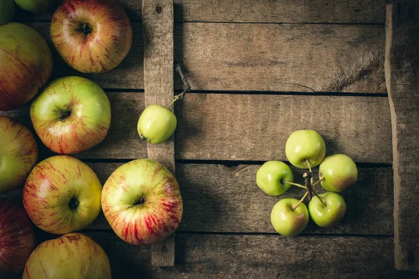 Зелені та червоні яблука на сільському столі. тонована фотографія . — стокове фото