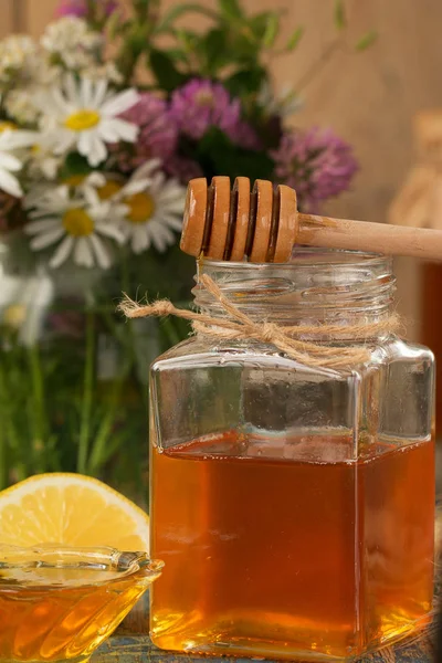 Honing in een pot of kruik op een houten tafel — Stockfoto