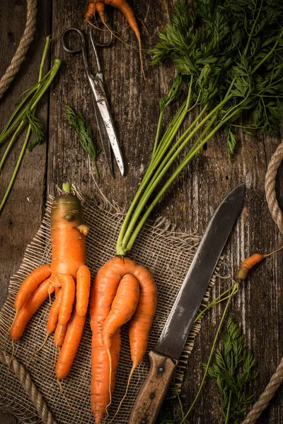 Unusual carrots on an old wooden table — Stock Photo, Image