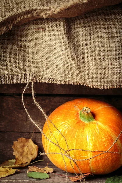 Hojas de calabaza y otoño sobre una vieja mesa de madera . —  Fotos de Stock