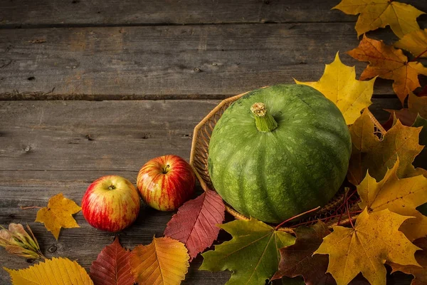 Grön pumpa och röda äpplen på rustika träbord — Stockfoto
