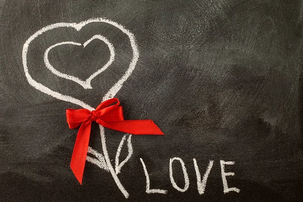 White LOVE greeting message with Heart symbol on blackboard