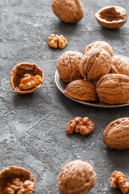 Karanlık taş zemin üzerine metal bir kase ceviz