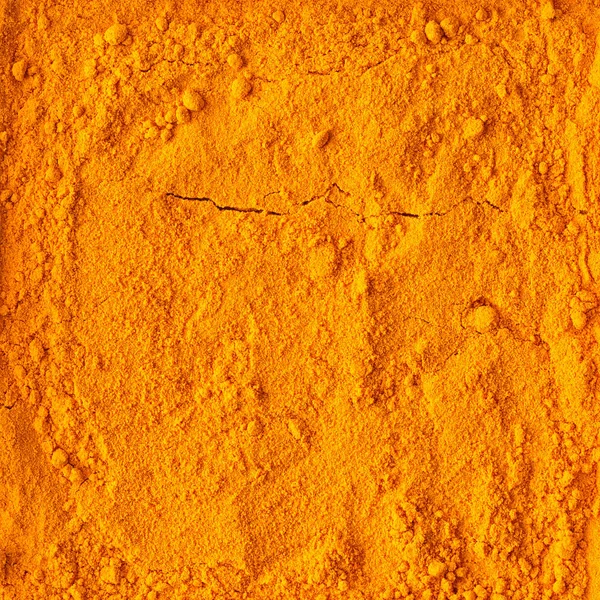 Kurkuma Puder Textur Hintergrund. Ansicht von oben — Stockfoto