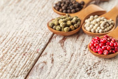 Ahşap masa üzerinde bir tahta kaşıklar farklı biber