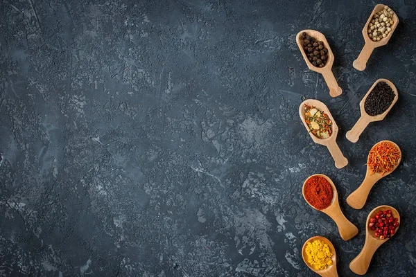 Spices and herbs over black stone background. Flat lay — Stock Photo, Image