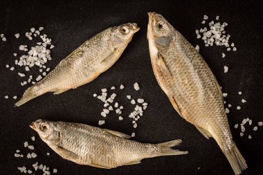 Kurutulmuş balık karanlık bir arka plan üzerinde. Üstten Görünüm, düz lay.