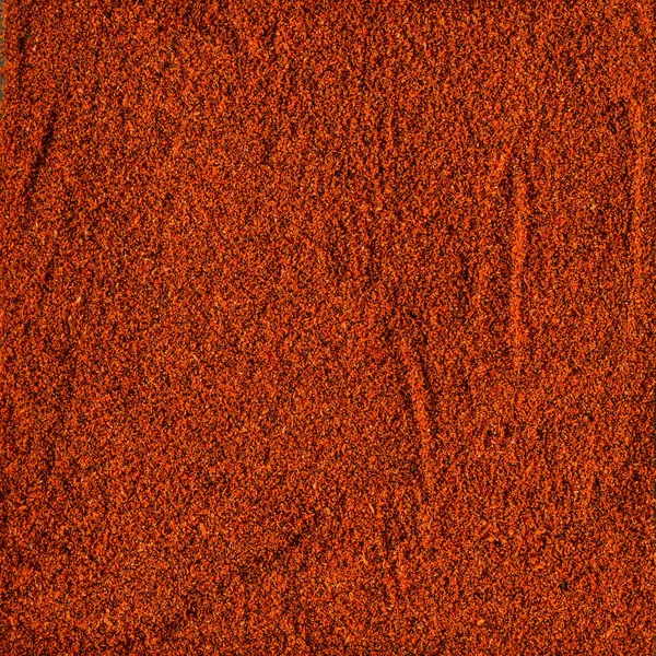 Superfície coberta com o pó de páprica vermelha — Fotografia de Stock