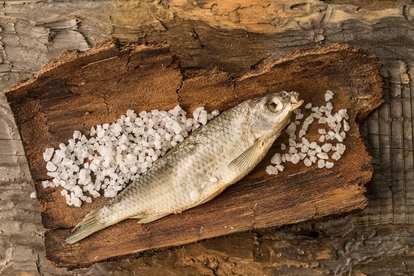 Gedroogde vis ligt op rustieke houten achtergrond — Stockfoto