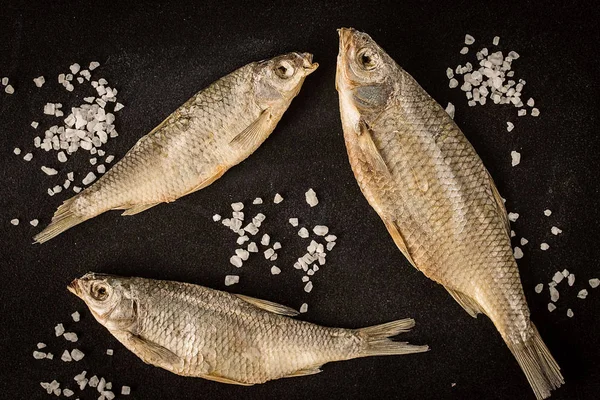 Kurutulmuş balık karanlık bir arka plan üzerinde. Üstten Görünüm, düz lay.
