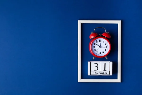 クリスマスの背景構成。青の古典的な背景にヴィンテージ目覚まし時計とホワイトフォトフレーム. — ストック写真