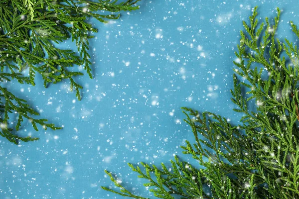 Boże Narodzenie tło gałązki jodły i płatki śniegu na niebieskim tle — Zdjęcie stockowe