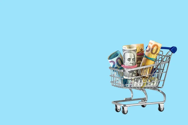 Shopping cart full of money isolated on blue background — 스톡 사진