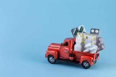 Toy car truck with pills on a blue background.