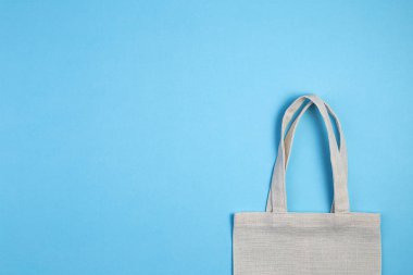 Reusable textile bag on blue background. Ecological concept.