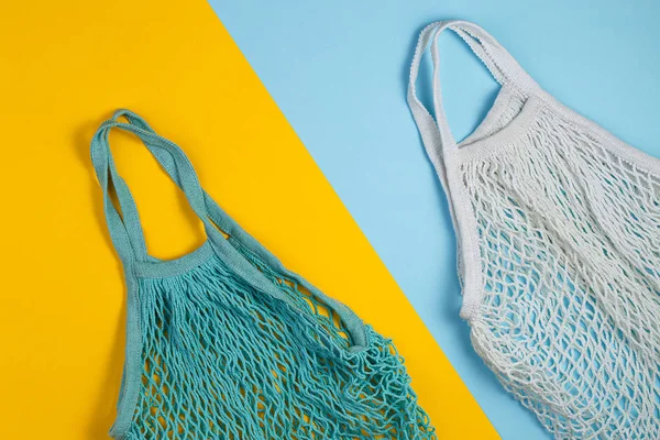 Zero waste concept. Two mesh shopping bags lie on yellow blue background — ストック写真