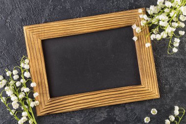 Karanlık bir arka planda fotoğraf çerçevesi olan bir buket narin zambak. Güzel bahar natürmort hayat konsepti. Üst Manzara Düz Yat