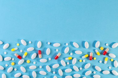 Tıbbi geçmişi var. Mavi arka planda çok renkli haplar var. Düz yatıyordu. Tıp konsepti. İlaç, antibiyotik, ilaç..