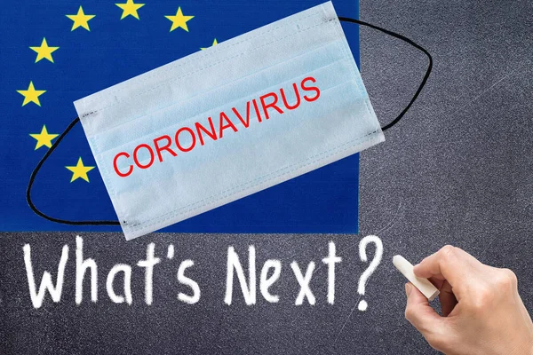 Europe union flag with disposable mask and CORONAVIRUS inscription. COVID-19 coronavirus epidemic in the United States of America. Global COVID-19 coronavirus pandemic
