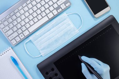 Ofiste hijyen var. Küresel salgın Coronavirus COVID 19 'u durdurun. Mavi arka planda lateks eldiven ve maskeden oluşan hijyen malzemeleri.