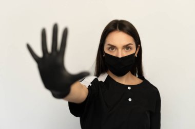 Coronavirus, siyah elbiseli, siyah koruyucu maskeli ve siyah eldivenli genç bir kız.