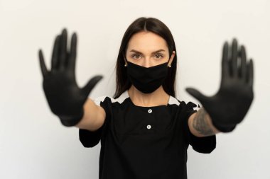 Coronavirus, siyah elbiseli, siyah koruyucu maskeli ve siyah eldivenli genç bir kız.