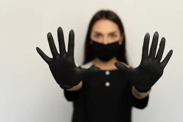 科罗纳维勒斯，一个戴着黑色防护面具和黑色手套的年轻女孩，穿着黑色衣服 — 图库照片