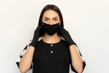 Coronavirus, siyah elbiseli, siyah koruyucu maskeli ve siyah eldivenli genç bir kız.