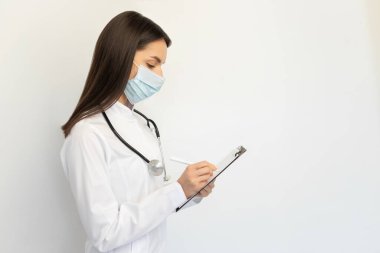 Koruyucu tıbbi maskeli, steteskoplu, dost canlısı bir kadın doktor. Covid-19 'a karşı koruma kavramı.