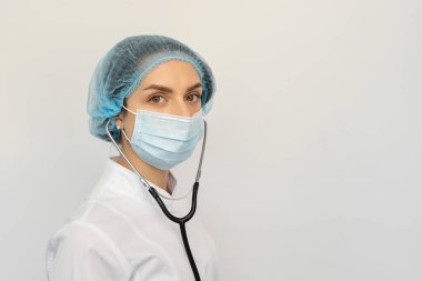 Elinde steteskopla koruyucu bir tıbbi maske takan bir doktoru kelepçele.