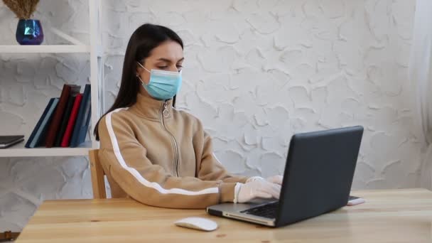 Una giovane donna in maschera protettiva medica e guanti che lavora durante la quarantena del COVID-19 . — Video Stock