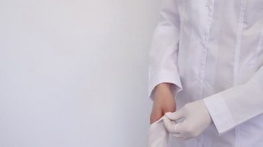 Beyaz önlüklü, koruyucu maskeli, giysi eldivenli, doktor kadın. Koronavirüs karantinası.