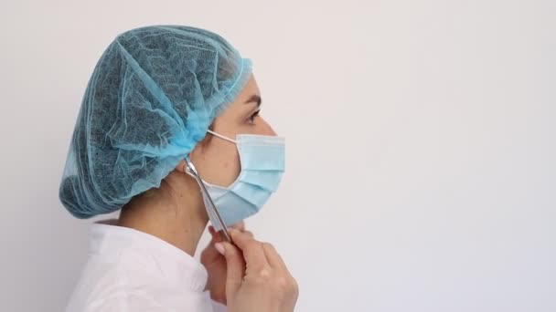 Close-up γιατρός γυναίκα σε λευκό ιατρικό παλτό καπέλο και προστατευτική μάσκα, στηθοσκόπιο ρούχα, covid19 coronavirus καραντίνα — Αρχείο Βίντεο
