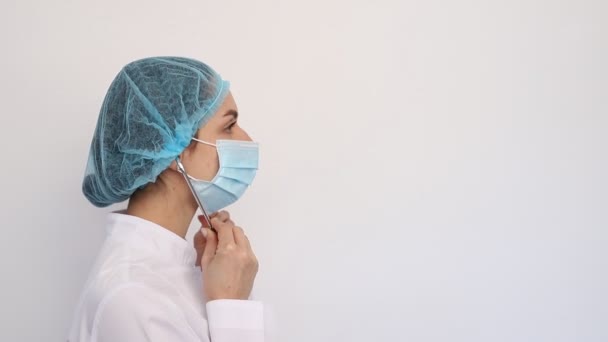 Крупным планом врач женщина в белом медицинском халате и защитной маске, одежда стетоскоп, covid19 коронавируса карантин — стоковое видео