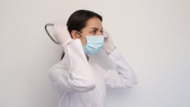 Beyaz tıbbi eldivenli kadın doktor ve koruyucu maske boynuna steteskop takıyor, insanlar ve tıp konsepti, kopyalama alanı.