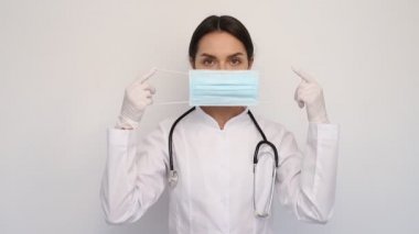 Beyaz tıbbi eldivenli kadın doktor ve koruyucu maske boynuna steteskop takıyor, insanlar ve tıp konsepti, kopyalama alanı.