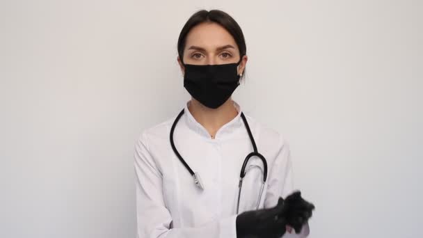 白い医療用手袋と保護マスクの女性医師は首や人や医療の概念に聴診器をつけ — ストック動画