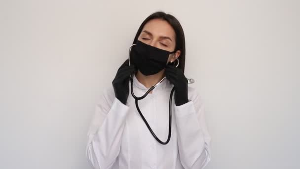 간호사 의사는 보호용 마스크와 청진기를 벗는다 암컷은 카메라를 보면서 미소를 — 비디오