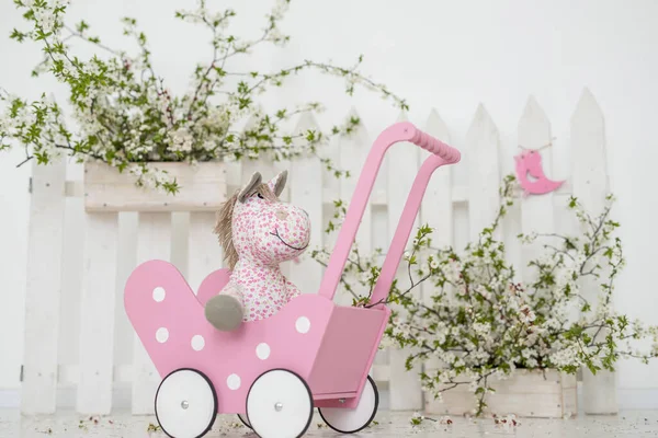 玩具用粉色木制婴儿车 粉色马 春季背景 — 图库照片