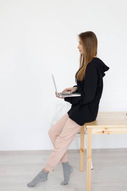 Genç, güzel, serbest çalışan bir bayan dizüstü bilgisayar üzerinde çalışıyor. Laptop, iş akışı konsepti, uzak bir iş yerinde kadın programcı.