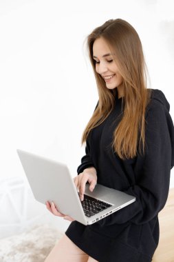 Genç, güzel, serbest çalışan bir bayan dizüstü bilgisayar üzerinde çalışıyor. Laptop, iş akışı konsepti, uzak bir iş yerinde kadın programcı.