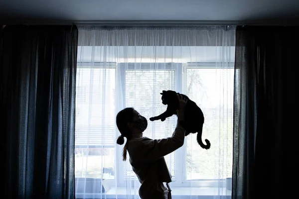 Mädchen Mit Selbstgebastelter Schutzmaske Hält Eine Schwarze Katze Arm Steht — Stockfoto