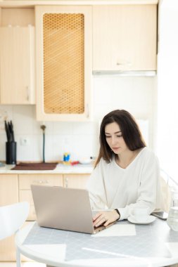 Evde çalışan serbest çalışan adam. Mutfakta dizüstü bilgisayarla çalışan kız. Uzaktan kumandalı yetenekli yönetici e-posta yazmak için dizüstü bilgisayarda çalışıyor. Uzak çalışma konsepti