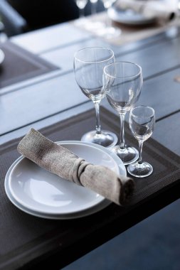 Konserve ahşap masa ve üç boş şarap kadehi. Beyaz ve kırmızı şarap için bir tür cam. Kutlama masasını kapatın.