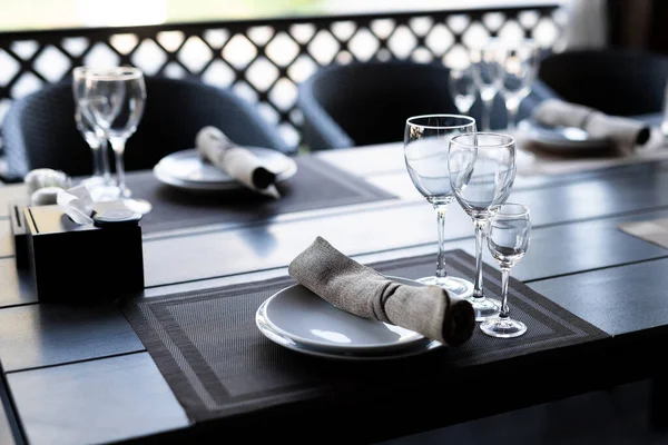 Canned wooden table with three empty wineglasses. Kind of glass for white and red wine. Close up celebration banguet table