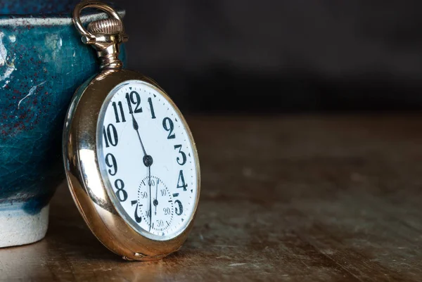 Vintage Golden Pocket Watch Resting on a Wooden Table